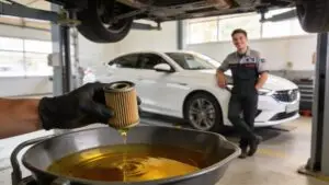 Mechanic replacing oil filter in auto shop