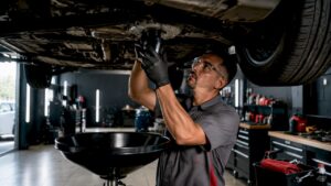 Technician changing oil at fast lube center