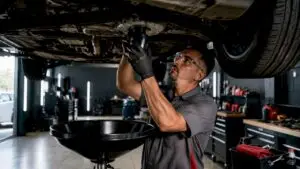 Technician changing oil at fast lube center
