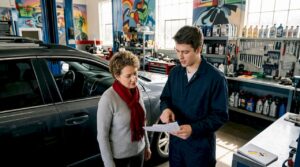Customer reviewing written repair estimate with mechanic