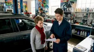 Customer reviewing written repair estimate with mechanic
