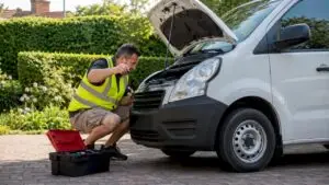 Delivery driver inspecting engine oil dipstick