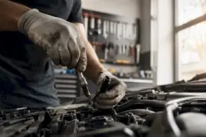 Technician hands removing spark plug from engine