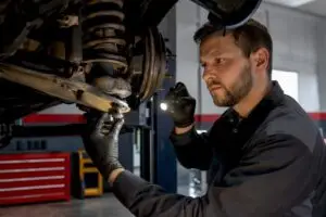 Technician inspecting a vehicle ball joint