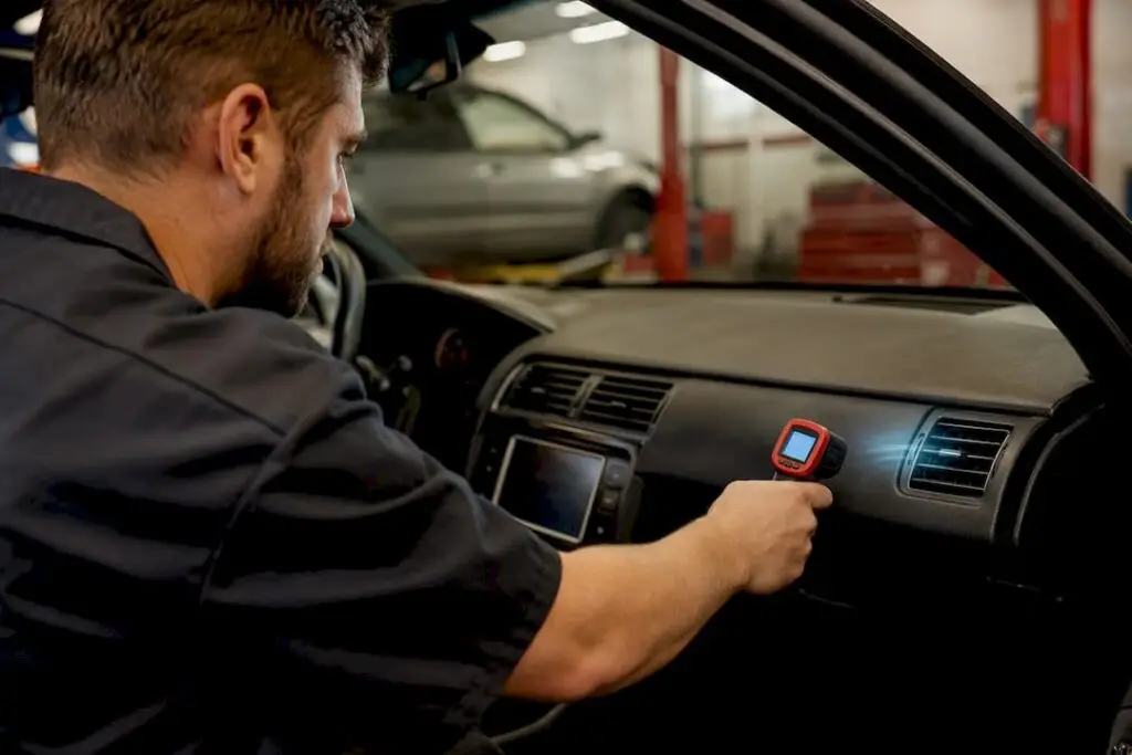 Technician checking airflow from car AC vent