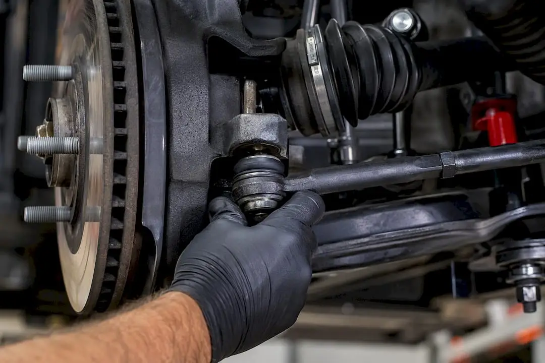 Technician inspecting steering and suspension joint
