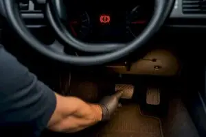 Technician testing brake pedal warning light