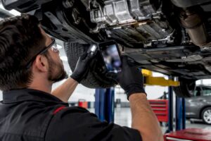 Technician photographing engine oil leak trace
