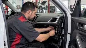 Technician inspecting a vehicle fuse panel