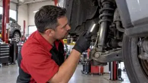 Technician inspecting a vehicle shock absorber
